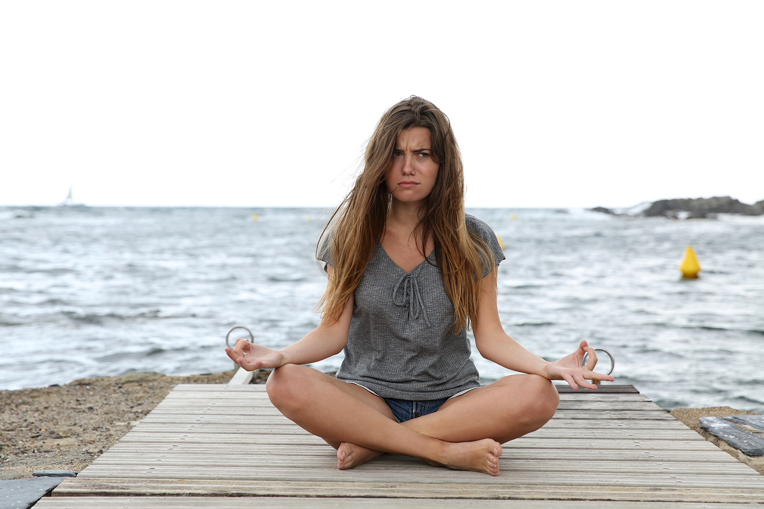 a frustrated woman trying to do half-lotus pose
