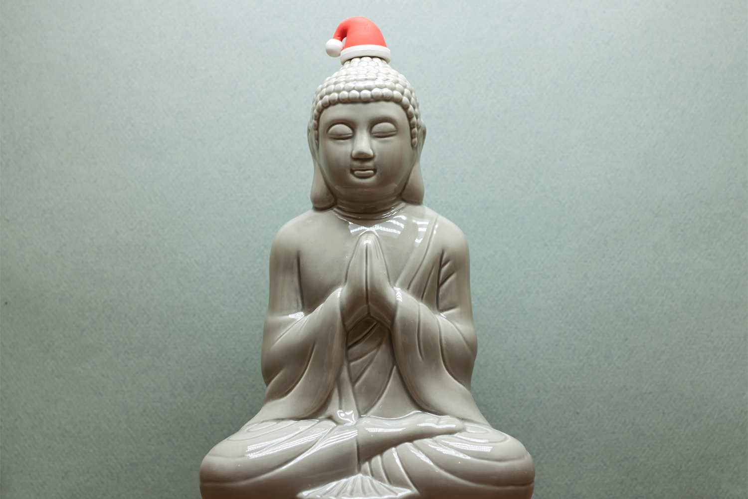 Mindfulness During the Holiday Season a statue of Siddhartha wearing a Santa hat