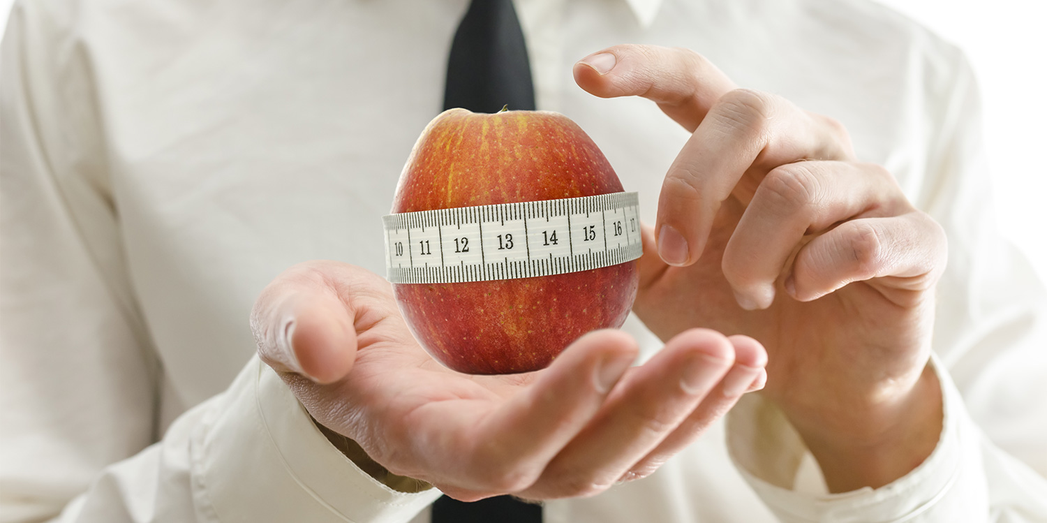How Health Coaches Are Contributing to a Diet Culture Full of Fear and Confusion An apple being measured for diameter