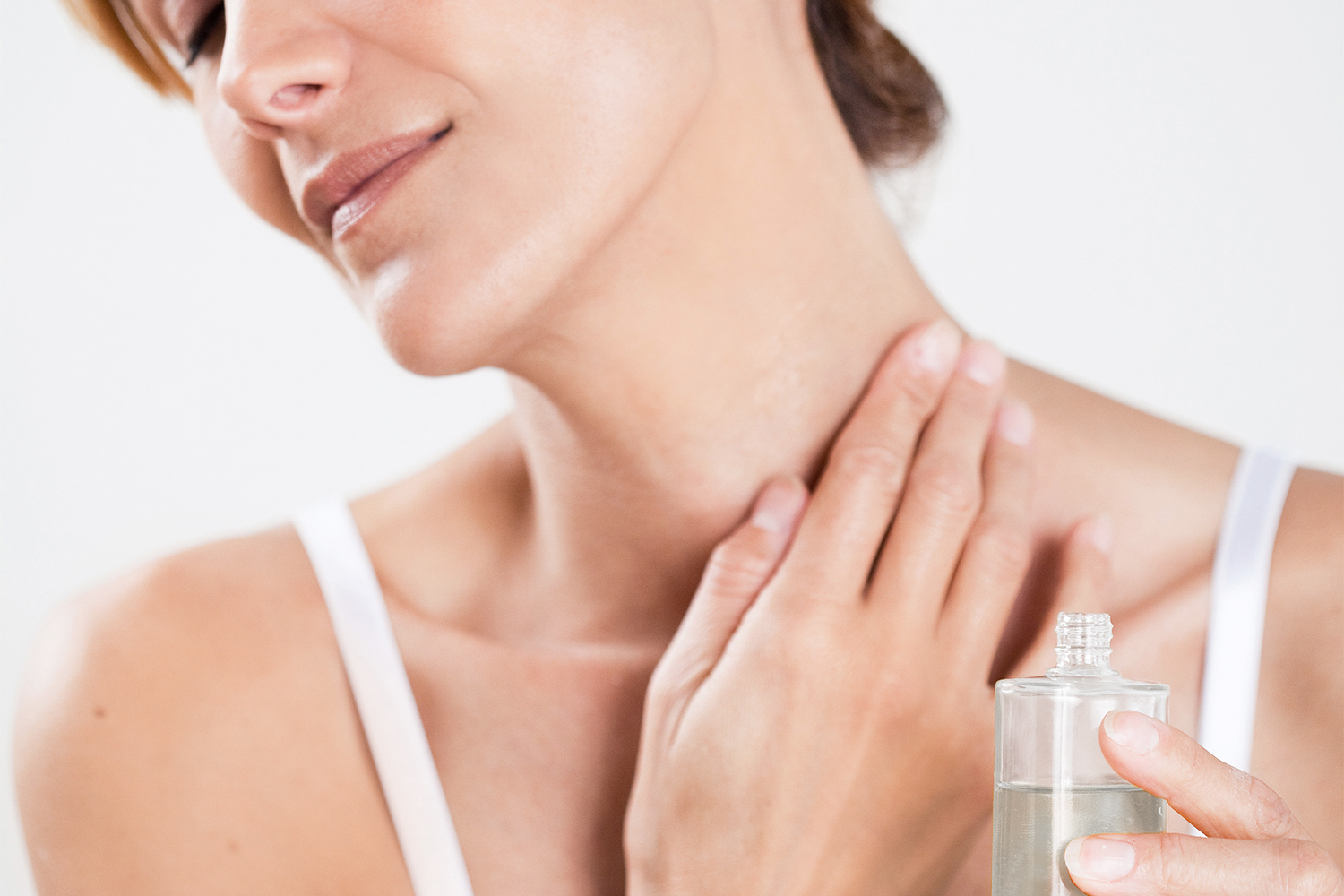 Health & Wisdom Topical Magnesium Oil a woman applying oil to her sore, stiff neck