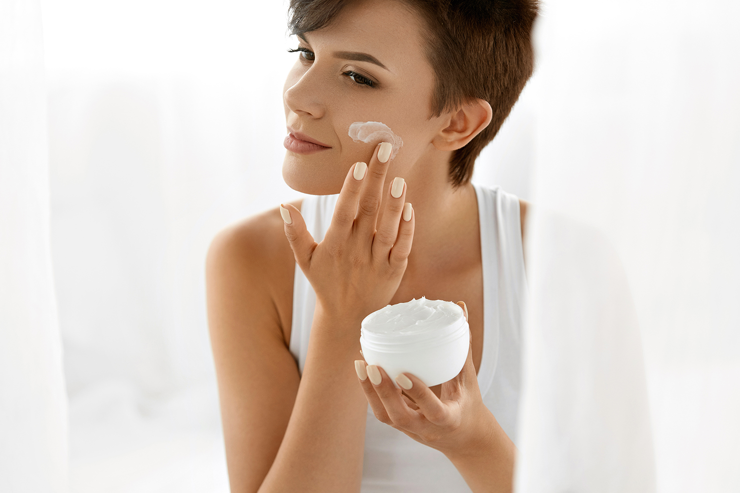 a woman applying skin cream to her face