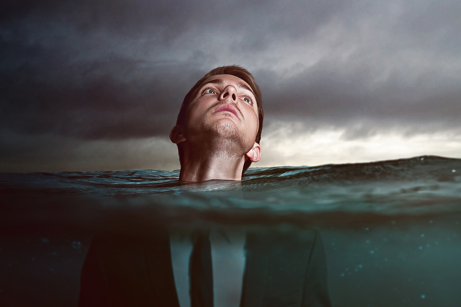 a man up to his neck in a stormy sea