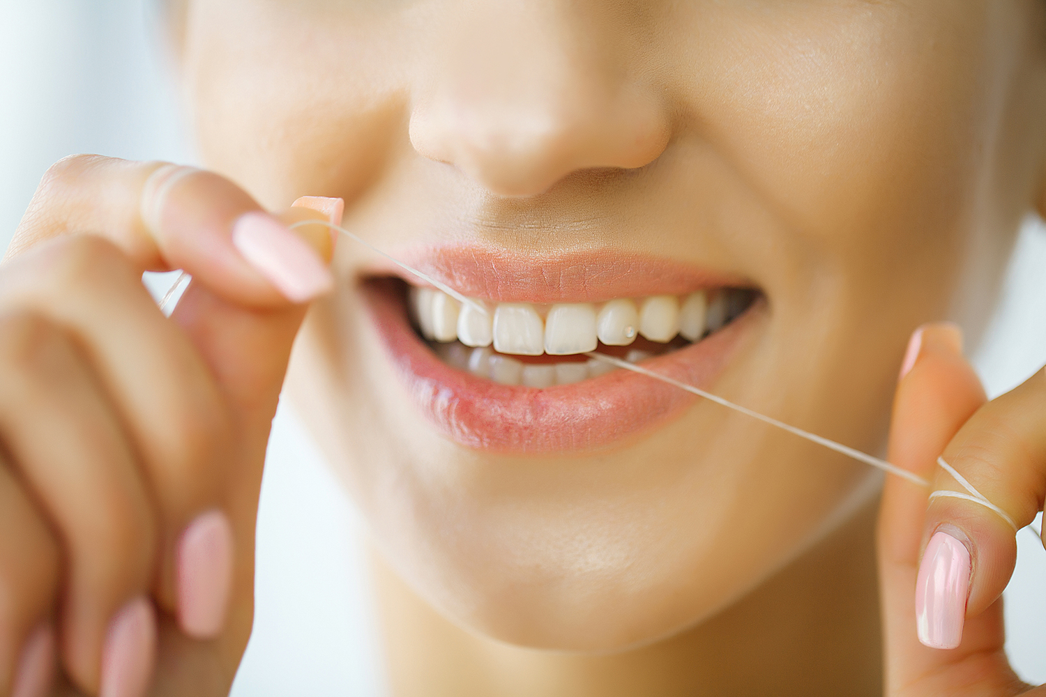 Woman flossing her teeth.