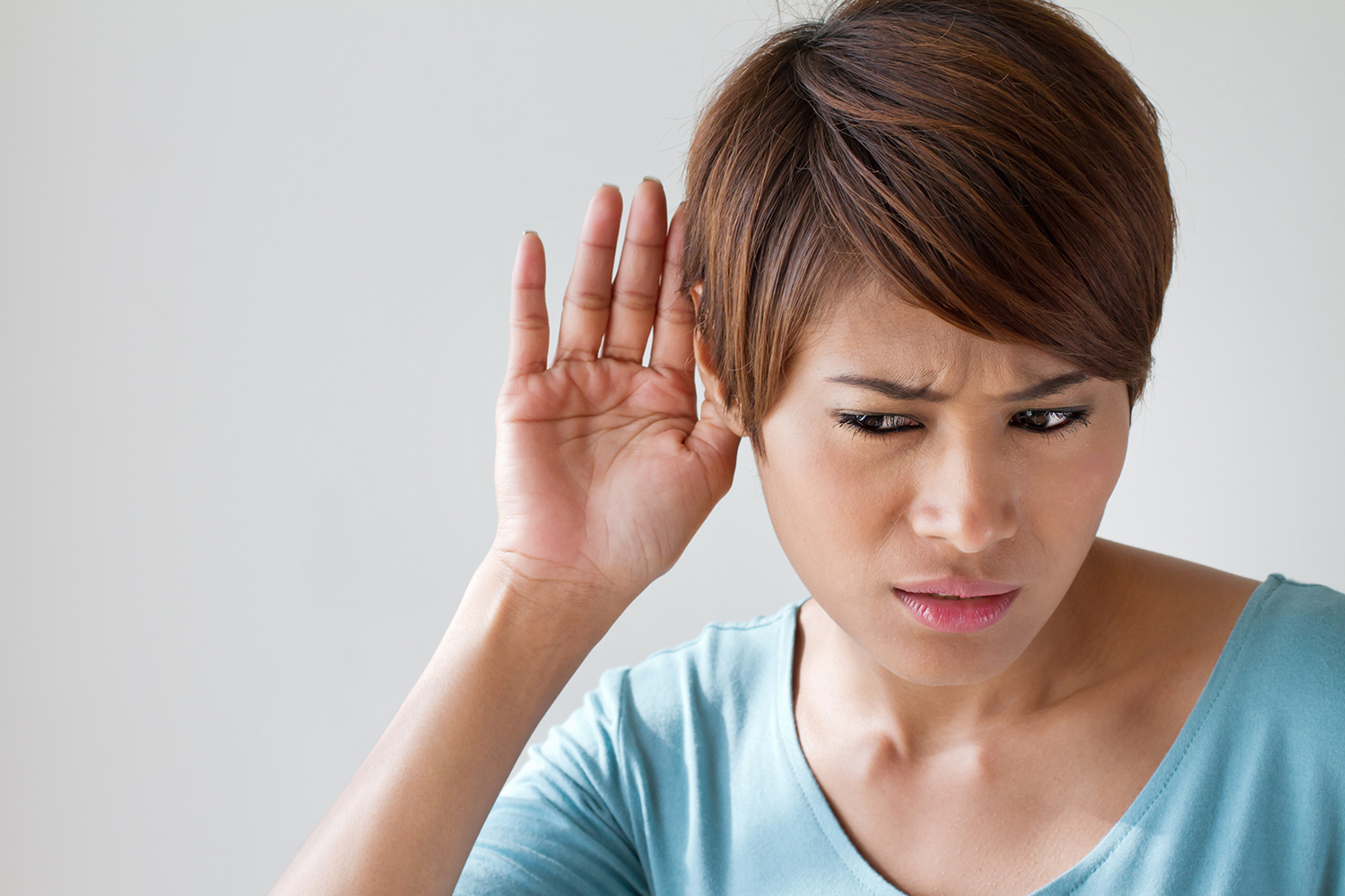 a woman straining to hear what's being said to her