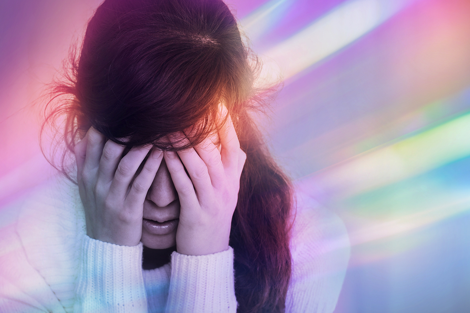 a dizzy woman with a headache, bathed in colored light