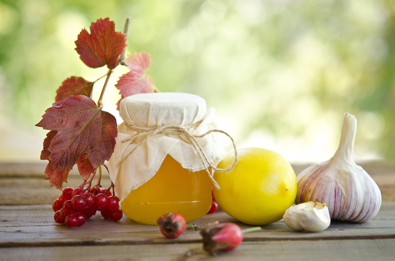 Honey and other natural medicine for winter flu, on a wooden table.
