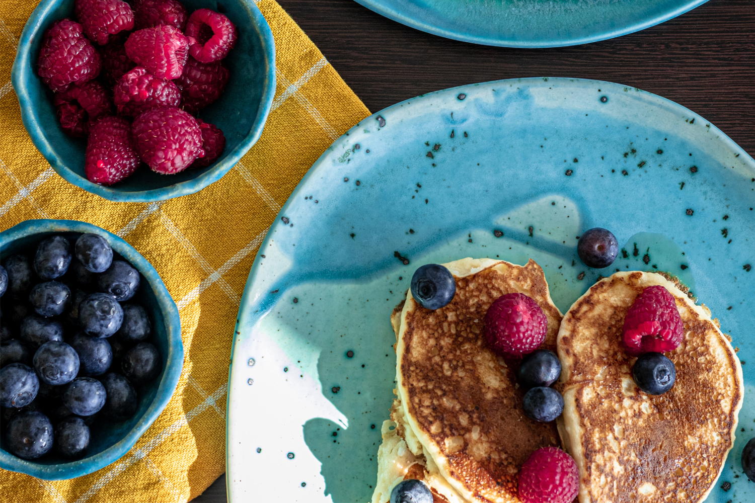 Finnish Oven Pancake with Berry Sauce a plate of pancakes and bowls of berries