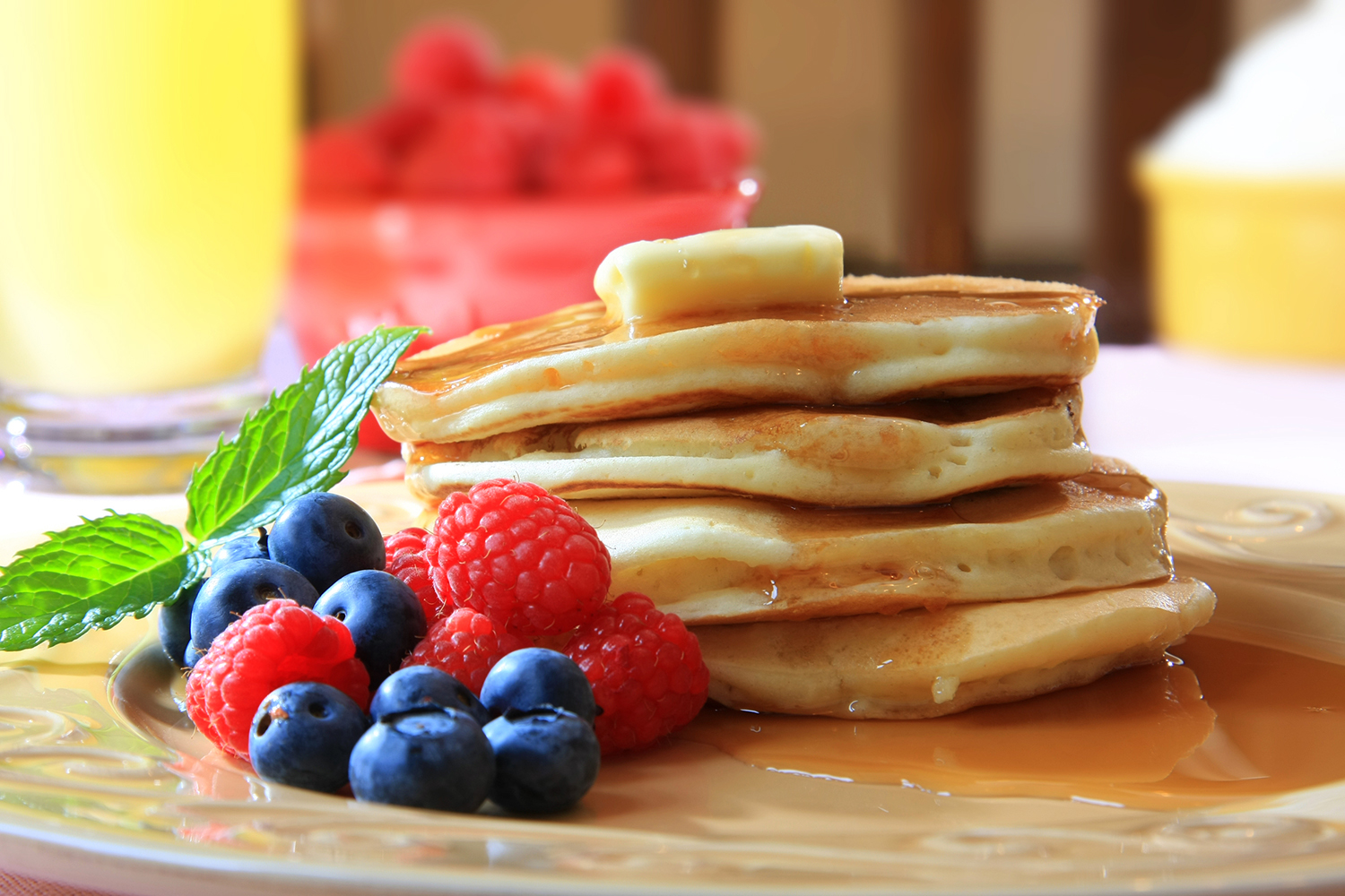 Freezer-Friendly Pancakes a stack of homemade pancakes from scratch with berries, syrup, and butter