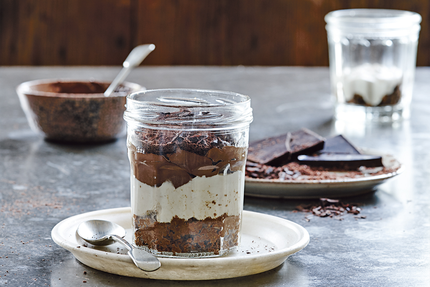 Tiramisu in a Jar Tiramisu in a clear jar on a white plate with spoon.