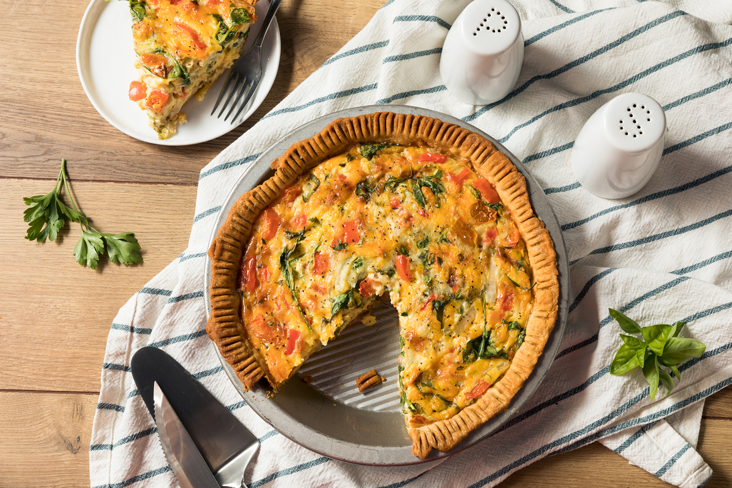 Spring Vegetable Quiche a pie tin of vegetable quiche missing a slice