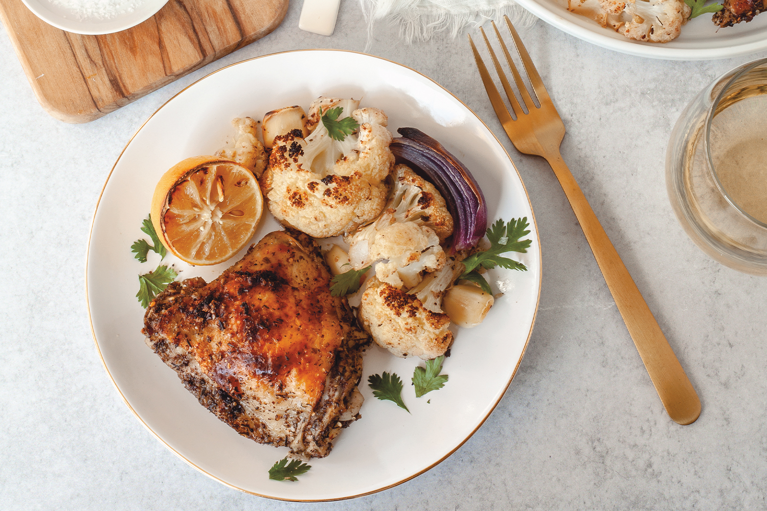 Crispy Za’atar Chicken and Cauliflower spicy chicken plated with lemon and onion