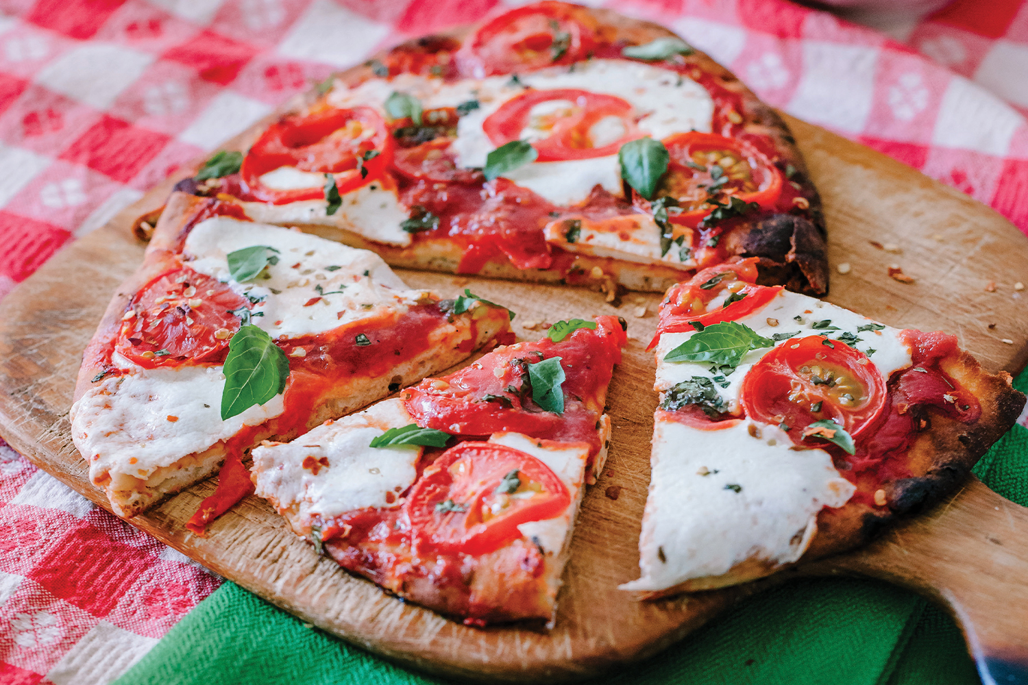 Margherita Flatbread Pizzas Margherita Flatbread Pizza on a wooden pizza board, cut and ready to serve.