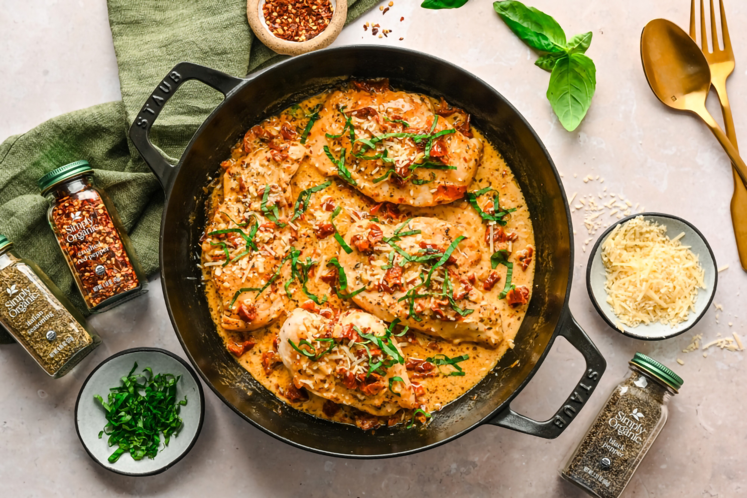 a skillet of chicken and sauce with herbs