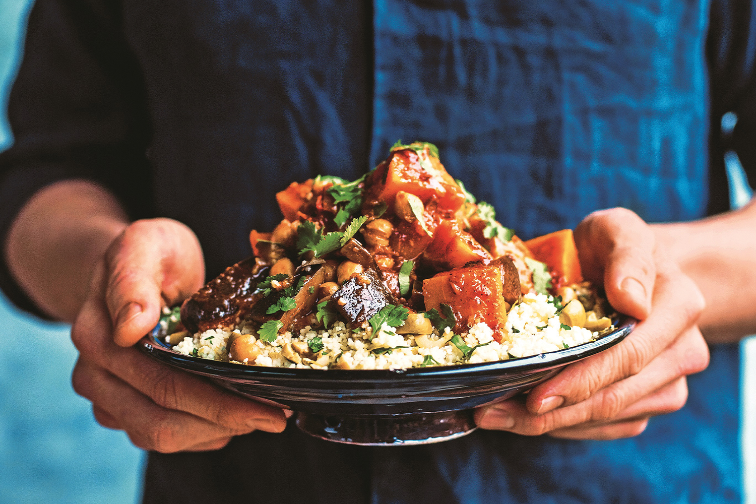 One-Pot Veggie Tagine A man holding a heaping plate of Veggie Tagine