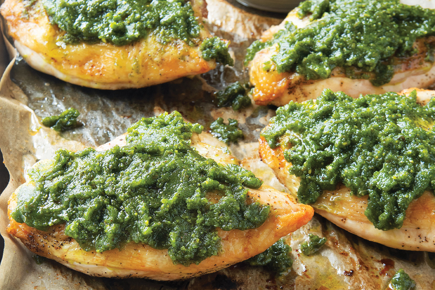 Pistachio Pesto Chicken Breast Pistachio Pesto Chicken on a baking sheet with parchment paper.