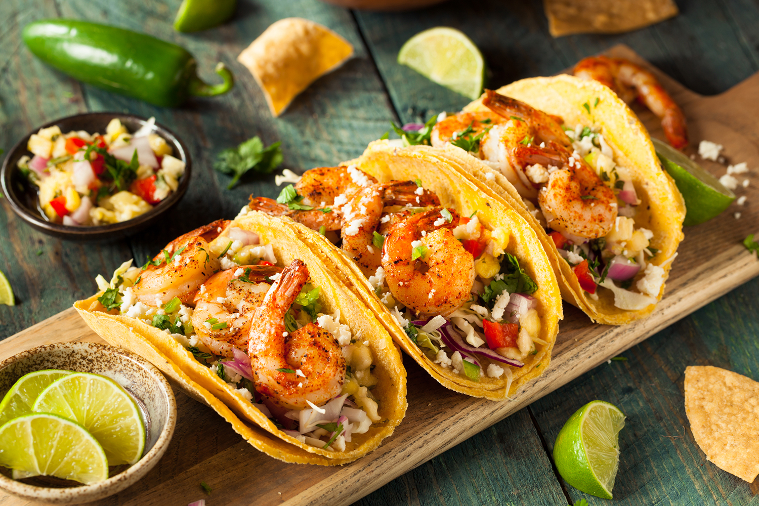 a serving board with loaded shrimp tacos
