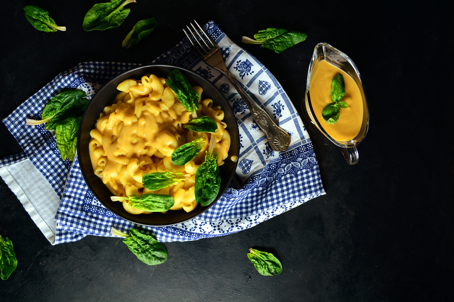 Stovetop Mac-and-Cheese with Spinach a bowl of vegan mac and cheese with extra cashew cheese on the side