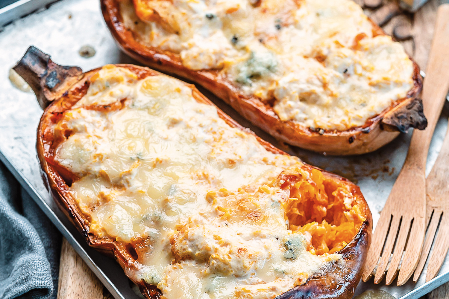Twice baked butternut squash fresh out of the oven on a baking sheet.