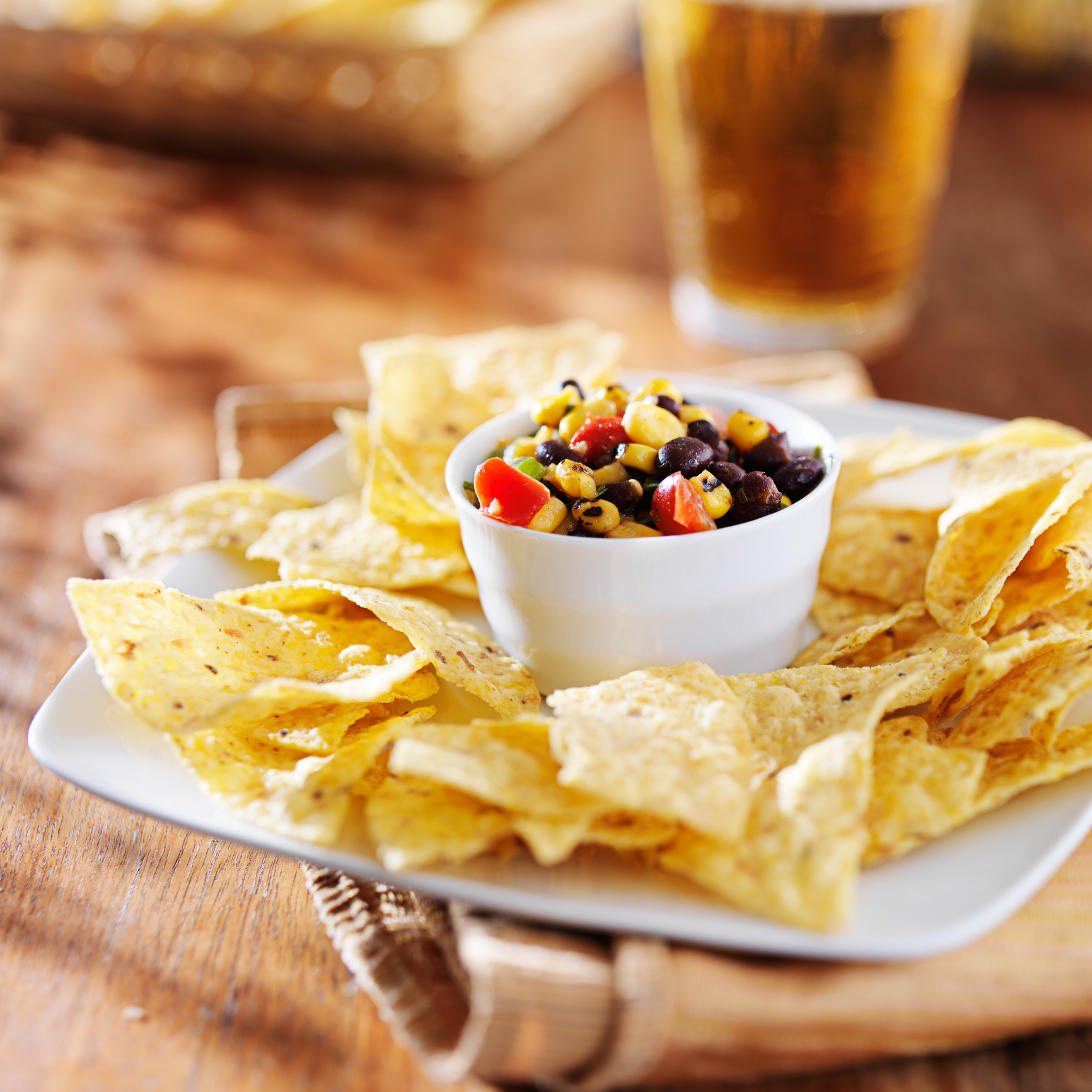 Plate of tortilla chips with a bowl of salsa in the middle. 