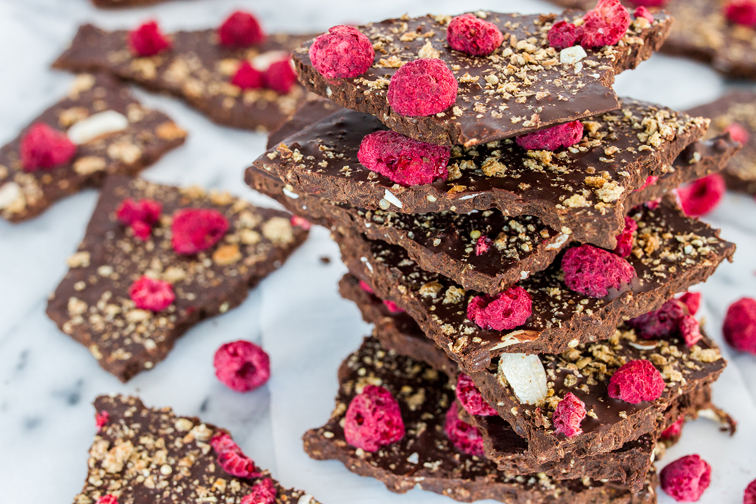 Crispy Chocolate Bark A stack of chocolate bark with raspberries and crispy almond and grain flakes