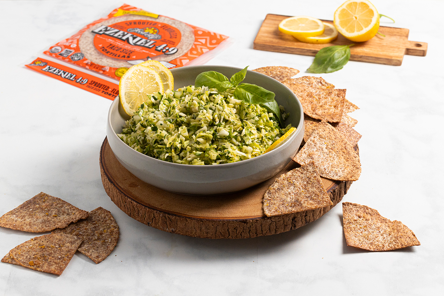a bowl of green vegetable dip with some tortilla chips