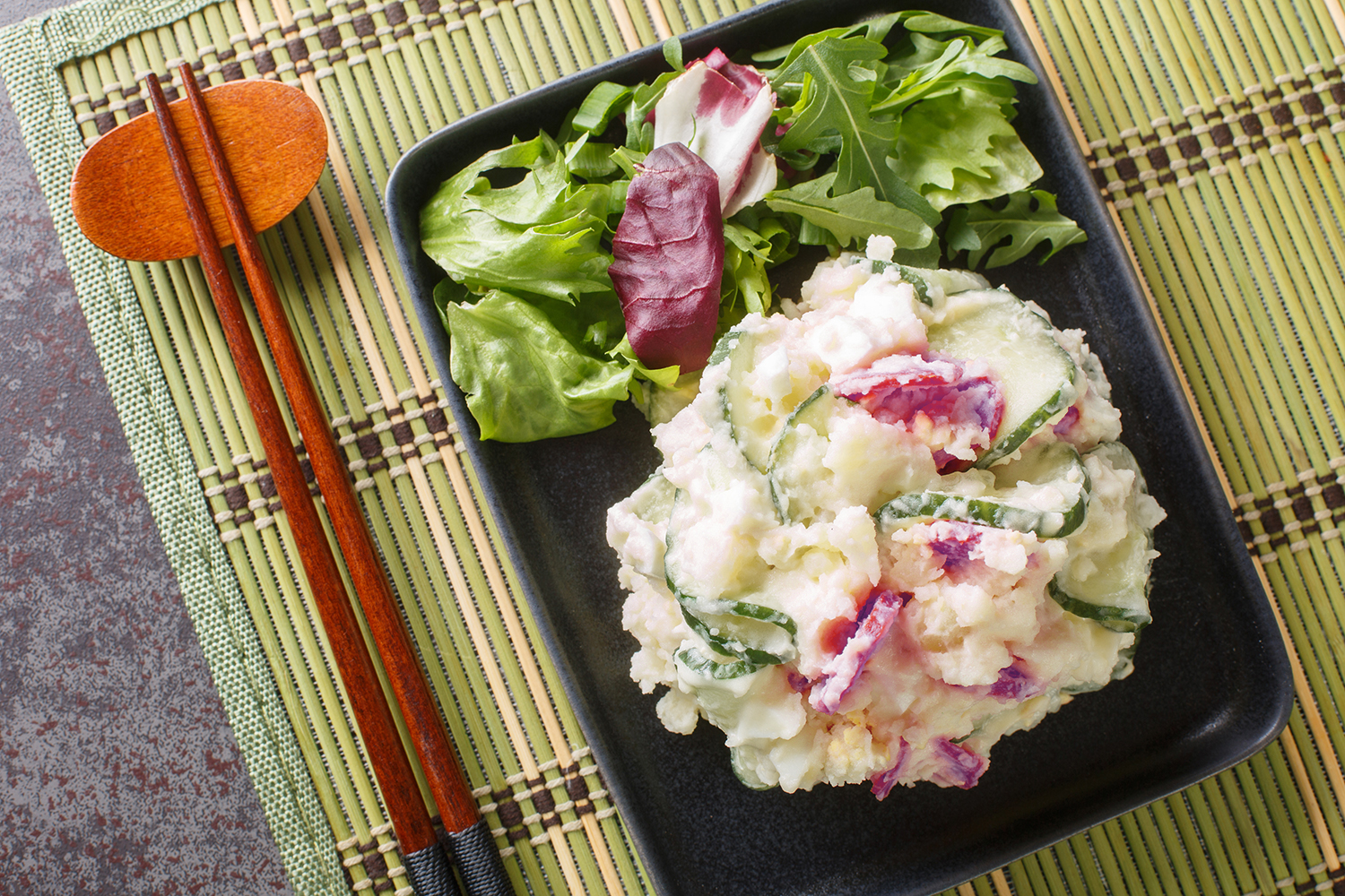 chopsticks and a bowl of mashed potatoes and vegetables