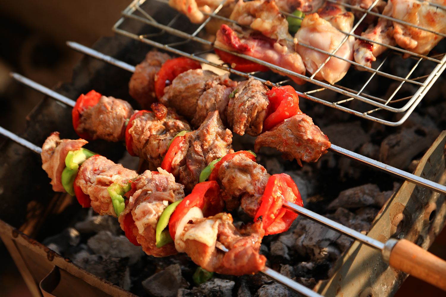 Spicy Caribbean Marinade shish kebabs and chicken legs over a charcoal grill