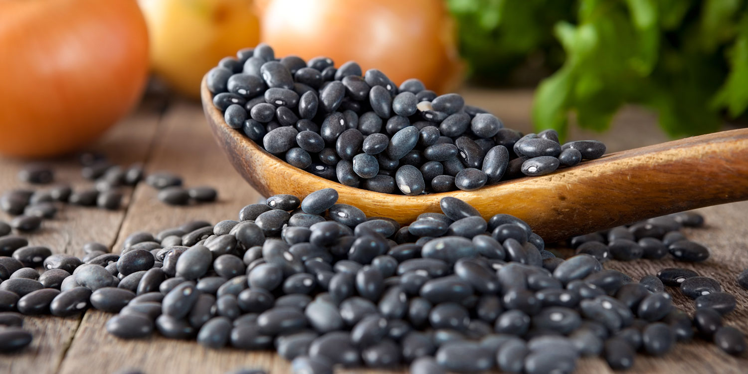 Black beans on a wooden spoon