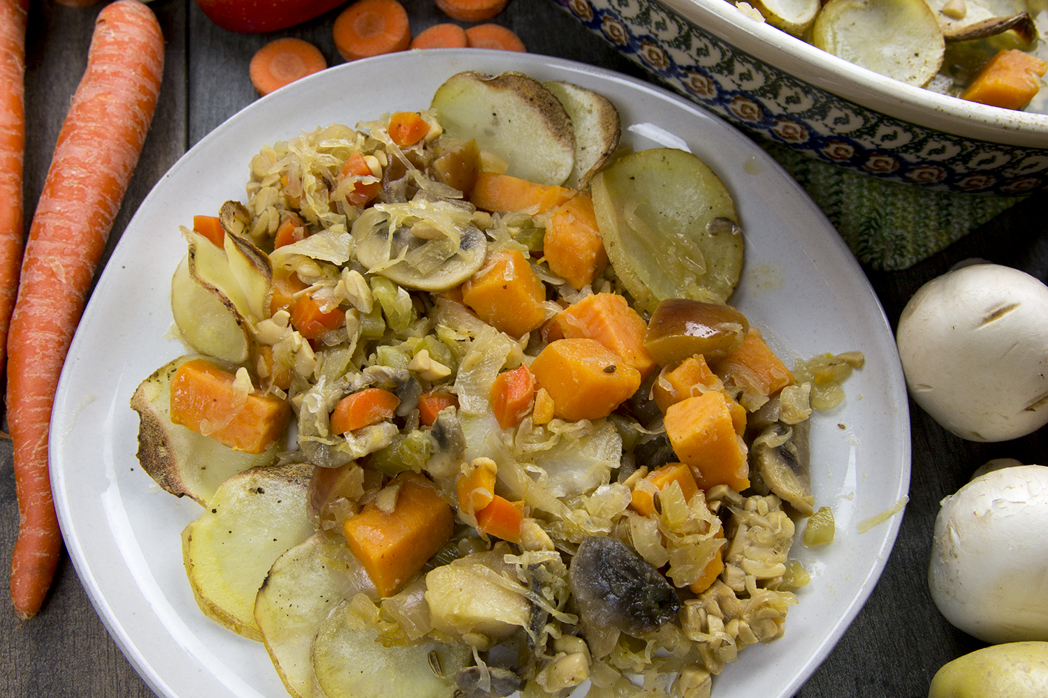 a dish of vegetables, sweet potatoes, and sauerkraut