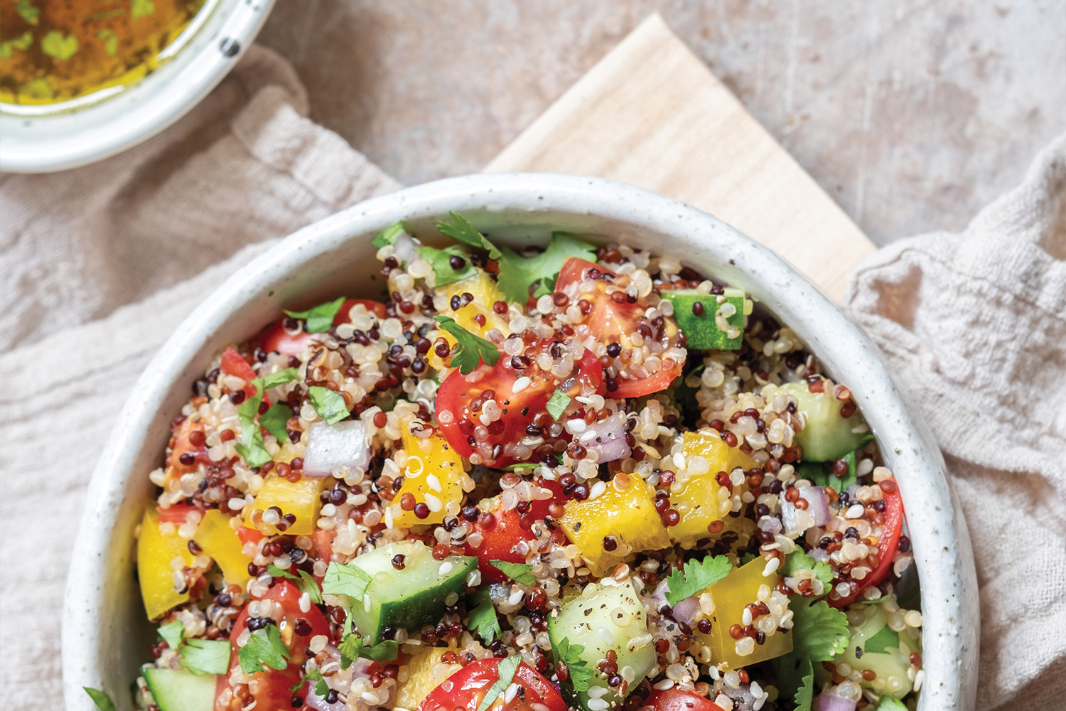 Quinoa Tabbouleh Top view of Quinoa Tabbouleh in a white bowl on flour sack cloth.