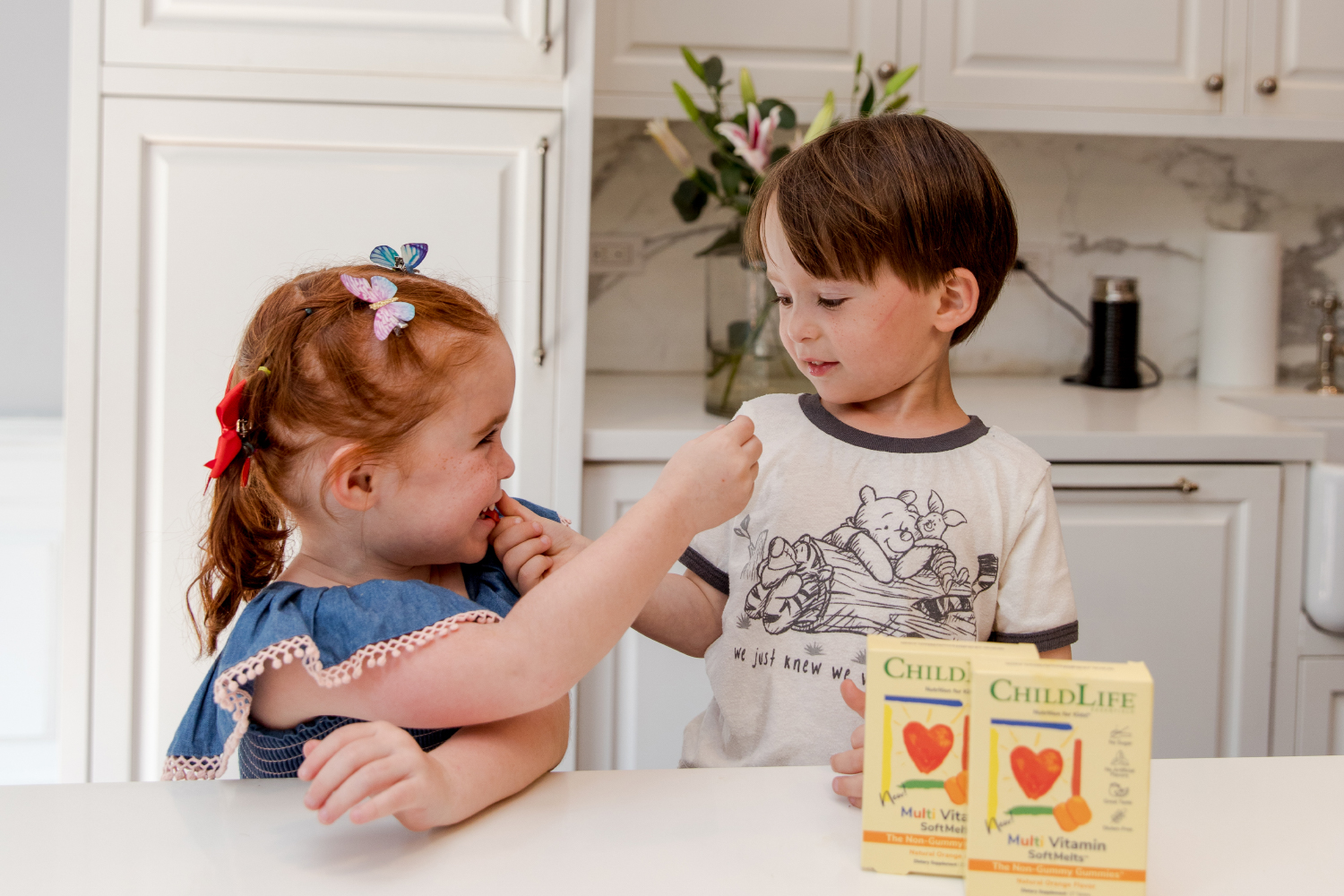 two toddlers sharing children's vitamins