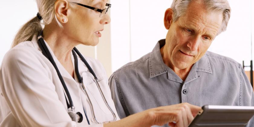 a doctor showing a man some healthy tips on a tablet