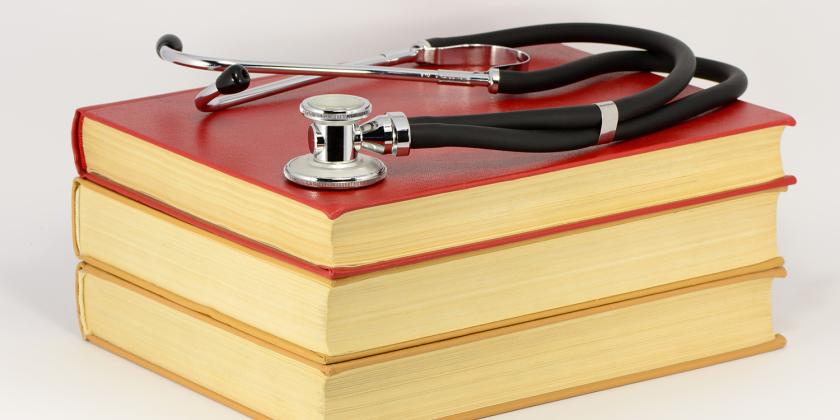 a stack of medical books with a stethoscope