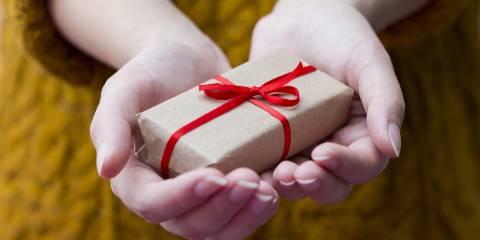 a woman holding out a small gift