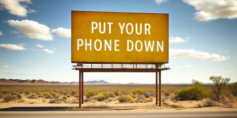 The Power of Real Connection Billboard in the desert that says "Put your phone down."
