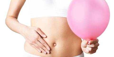 a woman feeling bloated, holding a balloon as a metaphor