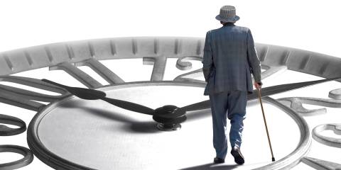 a senior man with a cane walking across a giant clock