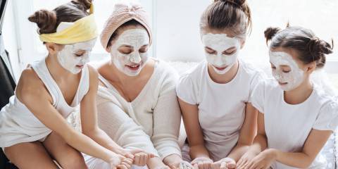 a family of young women applying skin care products