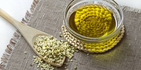 A spoonful of hemp seeds and a bowl of hemp seed oil