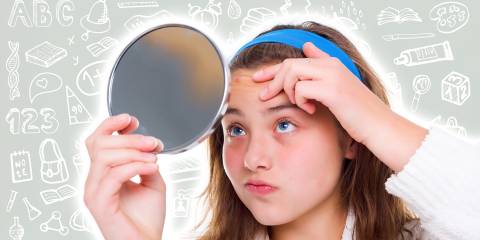 Start the New School Year Acne Free A school girl with a mirror, looking at a pimple on her forehead