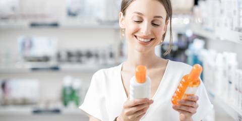 a woman comparing two containers of sunscreen
