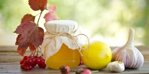 Honey and other natural medicine for winter flu, on a wooden table.