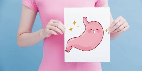 Managing IBD A woman holding an illustration of a happy stomach