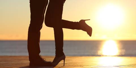 Heat Things Up! Silhouette of a couple's legs while embracing on the beach at sunset