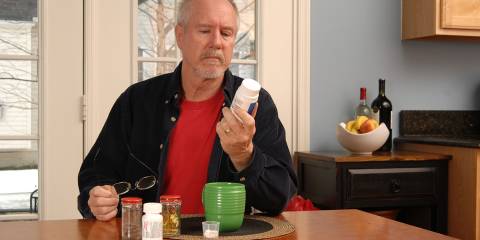 8 Supplements for Healthy Aging a retired man reading his supplement bottle