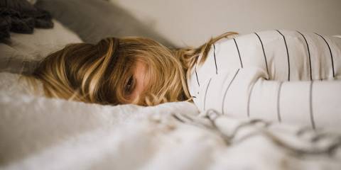 a woman collapsed on a bed from anxiety