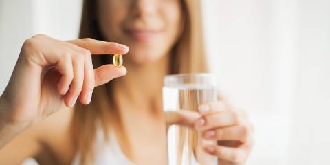 Natural Stress Relief a calm and happy woman taking a capsule of CBD