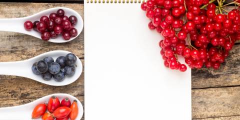 wild berries on wooden table with notebook 