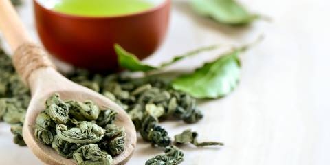 Green Tea for Weight Loss A spoon of dried leaves and a cup of green tea