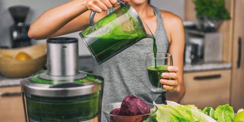 a woman using a juicer